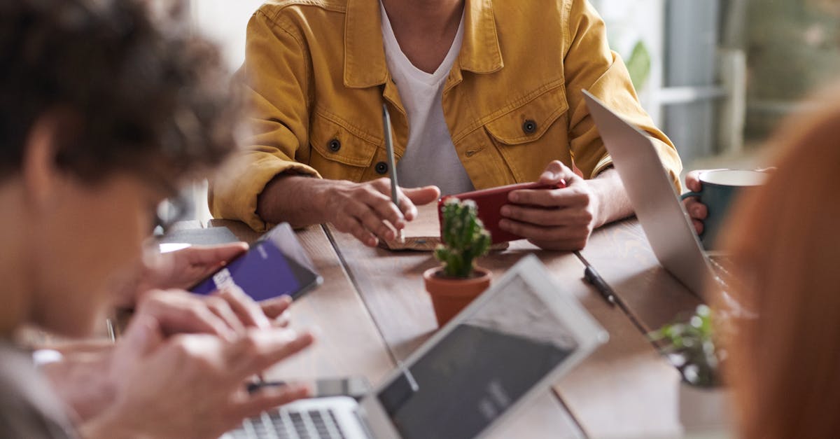 A group of professionals engaging in a team meeting around a wooden table in a modern office setting.